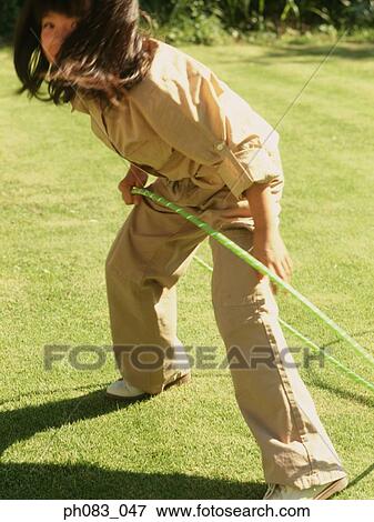 Stock Photo - Young girl playing with hula hoop. Fotosearch