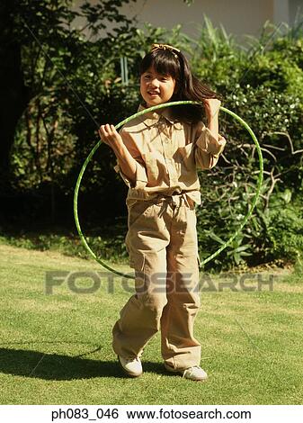 Young girl playing with hula hoop View Large Photo Image Stock Photograph - Young girl playing with hula hoop. Fotosearch