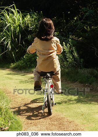 Young girl riding bicycle, rear view View Large Photo Image Stock Photograph - Young girl riding bicycle, rear view. Fotosearch