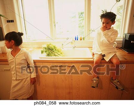 Boy sitting on basin area, girl looking away View Large Photo Image Stock Photo - Boy sitting on basin area, girl looking away. Fotosearch