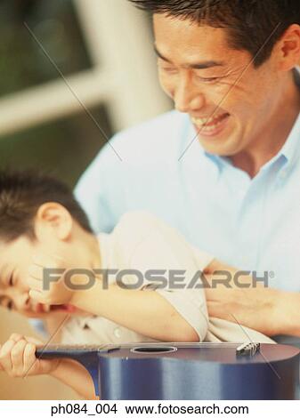 Picture - Father and son playing toy guitar. Fotosearch