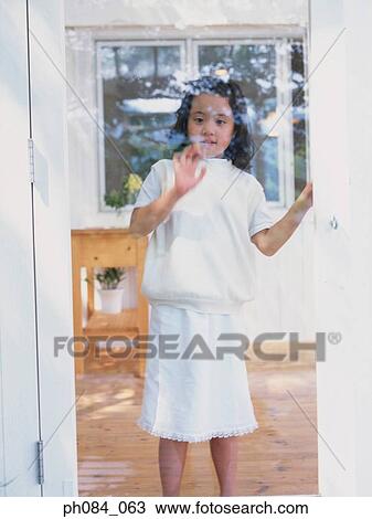 Stock Image - Girl standing at glass door. Fotosearch
