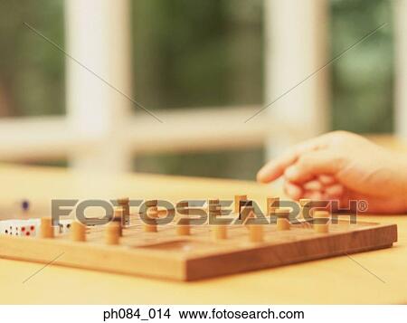 Picture - Hand resting beside a board game. Fotosearch