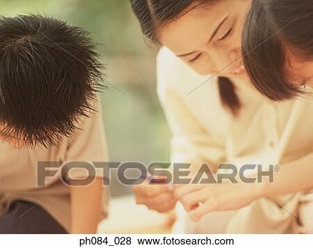 Stock Photo - Mother and children drawing using crayon. Fotosearch