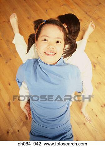 Mother and daughter back to back, high angle view View Large Photo Image Stock Image - Mother and daughter back to back, high angle view. Fotosearch