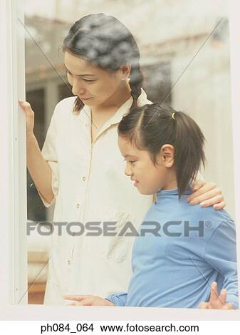 Mother and daughter standing by window View Large Photo Image Picture - Mother and daughter standing by window. Fotosearch