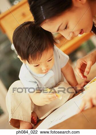 Stock Image - Mother and son drawing using crayon. Fotosearch