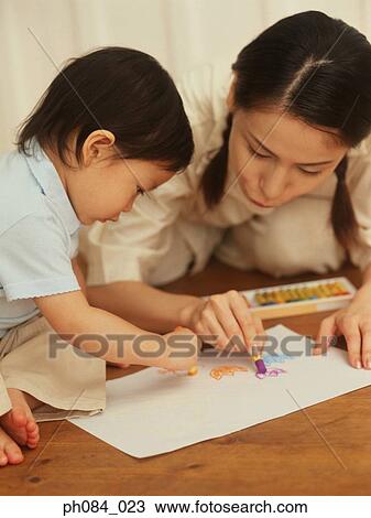 Stock Image - Mother and son drawing using crayon. Fotosearch