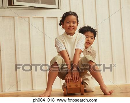 Sister and brother playing wooden toy car View Large Photo Image Stock Photo - Sister and brother playing wooden toy car. Fotosearch