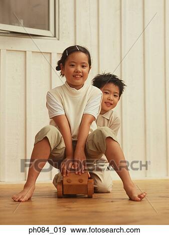 Sister and brother playing wooden toy car View Large Photo Image Stock Photo - Sister and brother playing wooden toy car. Fotosearch
