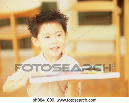 Young boy holding drawing materials View Large Photo Image Stock Photo - Young boy holding drawing materials. Fotosearch