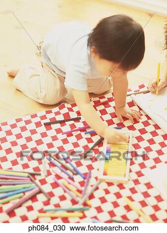 Stock Image - Young boy picking a crayon. Fotosearch