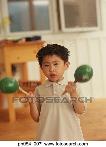 Young boy playing maracas View Large Photo Image Stock Photo - Young boy playing maracas. Fotosearch
