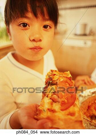 Young girl eating slice of pizza, close-up View Large Photo Image Picture - Young girl eating slice of pizza, close-up . Fotosearch
