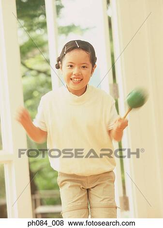 Stock Photo - Young girl playing maracas. Fotosearch