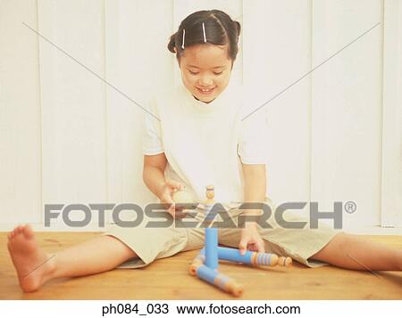 Stock Image - Young girl playing with wooden toy. Fotosearch