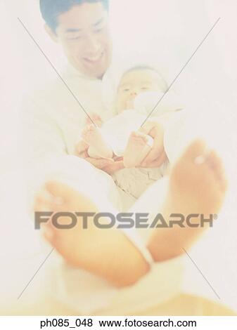 Stock Photo - Father holding a baby. Fotosearch