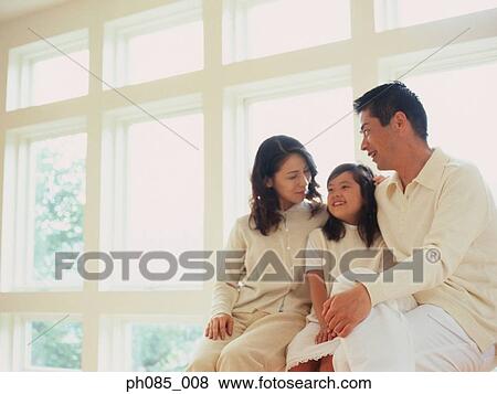 Father, mother and daughter sitting by window sill View Large Photo Image Stock Photo - Father, mother and daughter sitting by window sill. Fotosearch