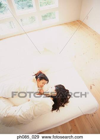 Mother and daughter lying on sofa View Large Photo Image Stock Photo - Mother and daughter lying on sofa. Fotosearch