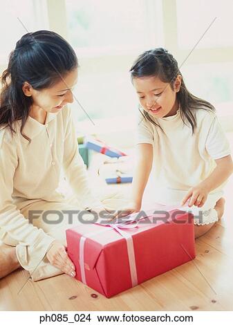 Mother and daughter opening a present View Large Photo Image Picture - Mother and daughter opening a present. Fotosearch