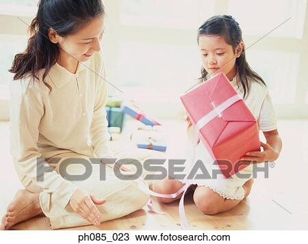 Mother and daughter opening a present View Large Photo Image Stock Image - Mother and daughter opening a present. Fotosearch