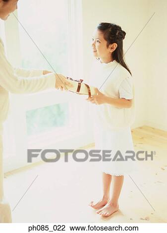 Mother giving daughter a present View Large Photo Image Stock Image - Mother giving daughter a present. Fotosearch