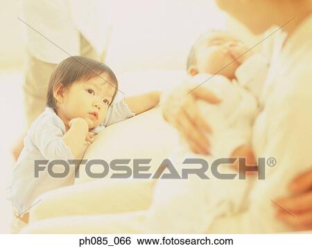 Mother holding baby, young son watching View Large Photo Image Stock Photograph - Mother holding baby, young son watching. Fotosearch