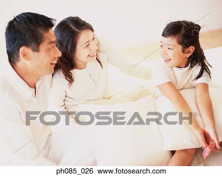 Parents and daughter chatting on sofa View Large Photo Image Stock Photograph - Parents and daughter chatting on sofa. Fotosearch