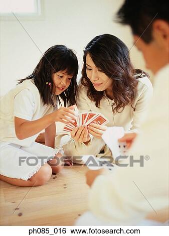 Parents and daughter playing cards View Large Photo Image Stock Photograph - Parents and daughter playing cards. Fotosearch