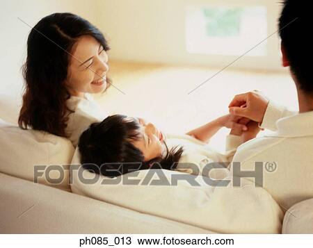 Parents and daughter playing on sofa View Large Photo Image Stock Image - Parents and daughter playing on sofa. Fotosearch