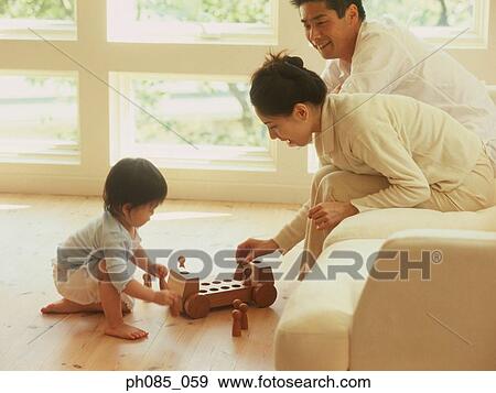 Stock Photo - Parents and son playing with wooden toy. Fotosearch