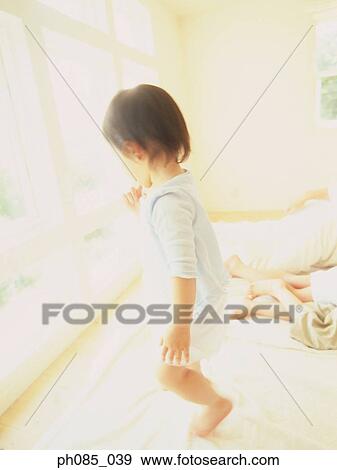 Young boy standing on bed View Large Photo Image Stock Photo - Young boy standing on bed. Fotosearch