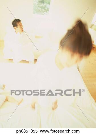 Young girl jumping on bed, father in background View Large Photo Image Stock Photography - Young girl jumping on bed, father in background. Fotosearch