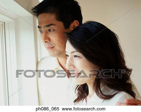 An Asian couple, looking out of window View Large Photo Image Stock Photography - An Asian couple, looking out of window. Fotosearch