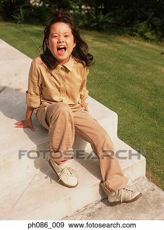 Stock Photo - Girl sitting on steps, laughing, portrait . Fotosearch