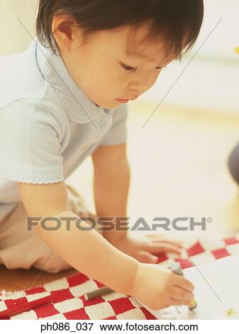 Stock Photo - Little girl drawing using crayon. Fotosearch