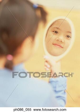 Little girl looking holding a mirror, looking at herself View Large Photo Image Stock Photography - Little girl looking holding a mirror, looking at herself. Fotosearch