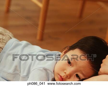 Little girl lying on sofa View Large Photo Image Stock Image - Little girl lying on sofa. Fotosearch