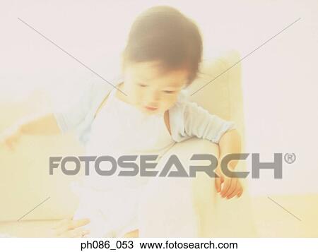 Stock Image - Little girl on sofa. Fotosearch