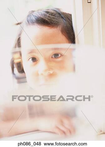 Stock Photo - Portrait of a girl behind window. Fotosearch