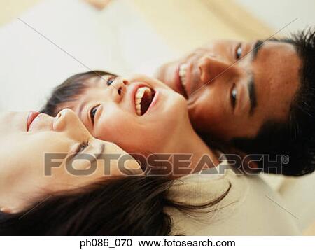 Stock Image - Portrait of father, mother and daughter. Fotosearch