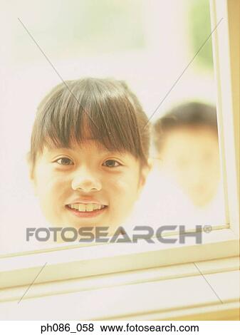 Sister looking through window, brother in the background View Large Photo Image Stock Photo - Sister looking through window, brother in the background. Fotosearch