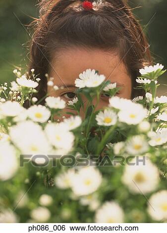 Young girl hiding behind flowers View Large Photo Image Stock Photograph - Young girl hiding behind flowers. Fotosearch