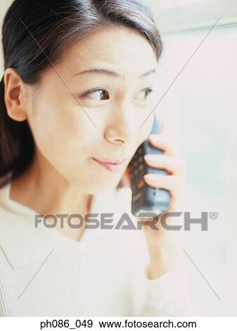 Stock Photo - Young woman using mobile phone, close-up . Fotosearch