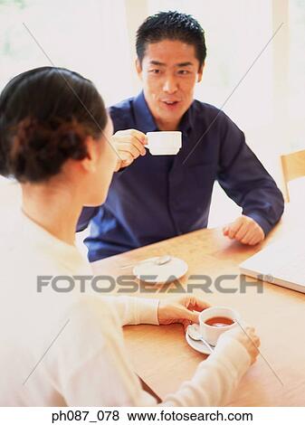 Couple having coffee and chatting View Large Photo Image Stock Photo - Couple having coffee and chatting. Fotosearch