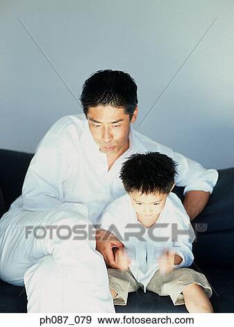 Stock Photo - Father and son playing TV game. Fotosearch