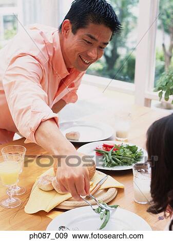 Father serving greens to daughter View Large Photo Image Stock Photo - Father serving greens to daughter. Fotosearch