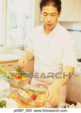 Man in kitchen preparing food View Large Photo Image Stock Photography - Man in kitchen preparing food. Fotosearch