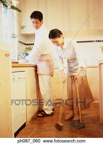 Man washing plates, while woman sweeping floor View Large Photo Image Stock Image - Man washing plates, while woman sweeping floor. Fotosearch