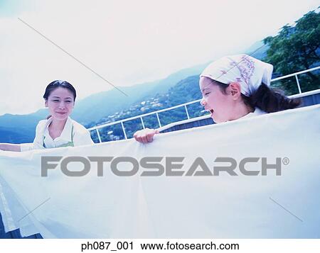 Mother and daughter hanging blanket on clothesline View Large Photo Image Stock Image - Mother and daughter hanging blanket on clothesline. Fotosearch